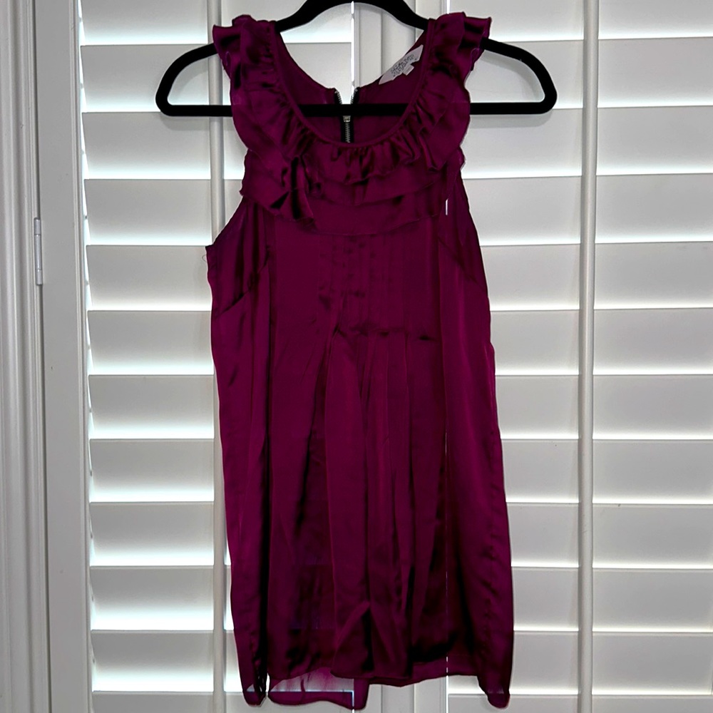 Cute flowy blouse with ruffle detail. Color is between purple/ dark pink